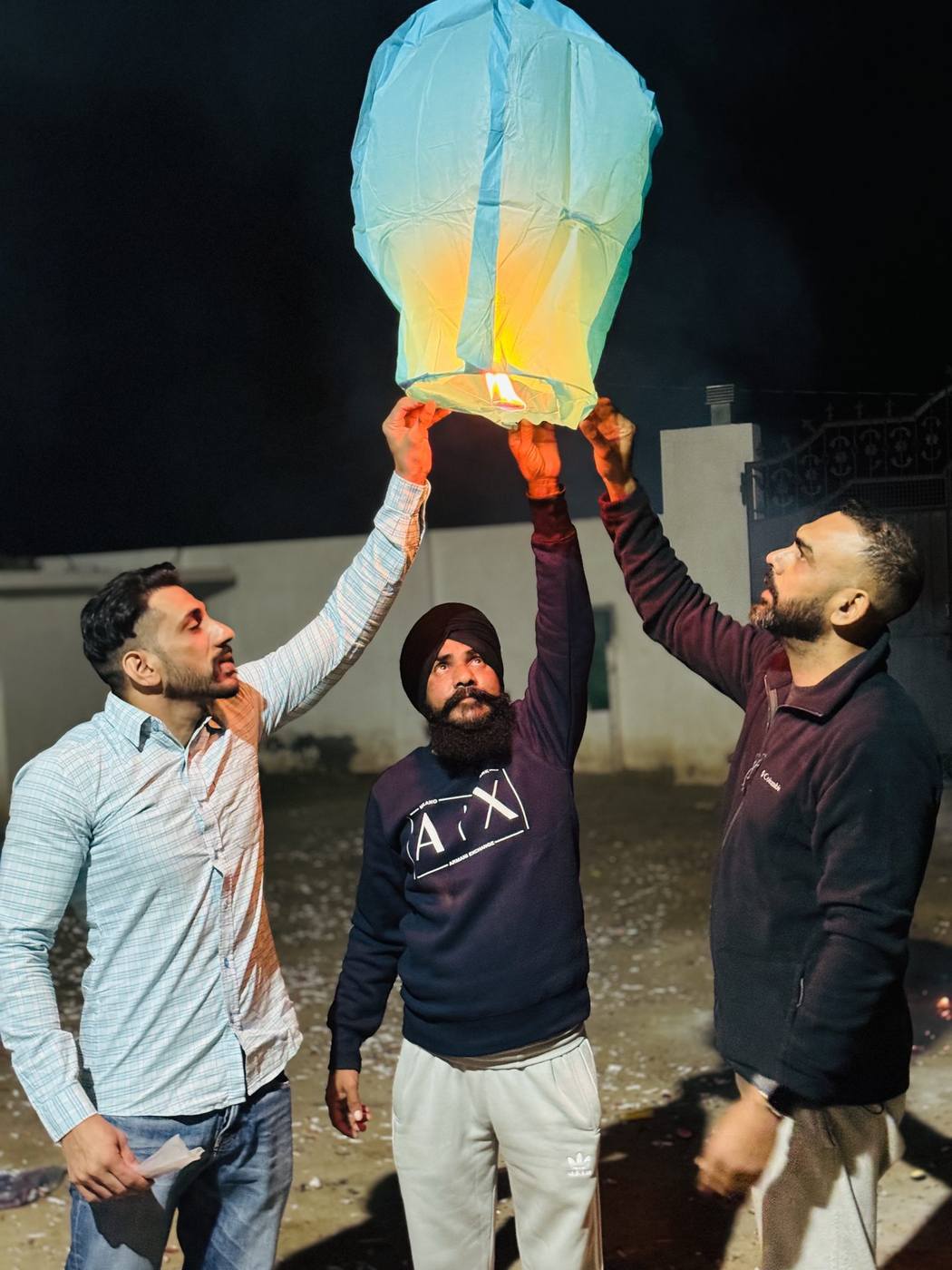 Residents releasing lanterns at night at Aasra